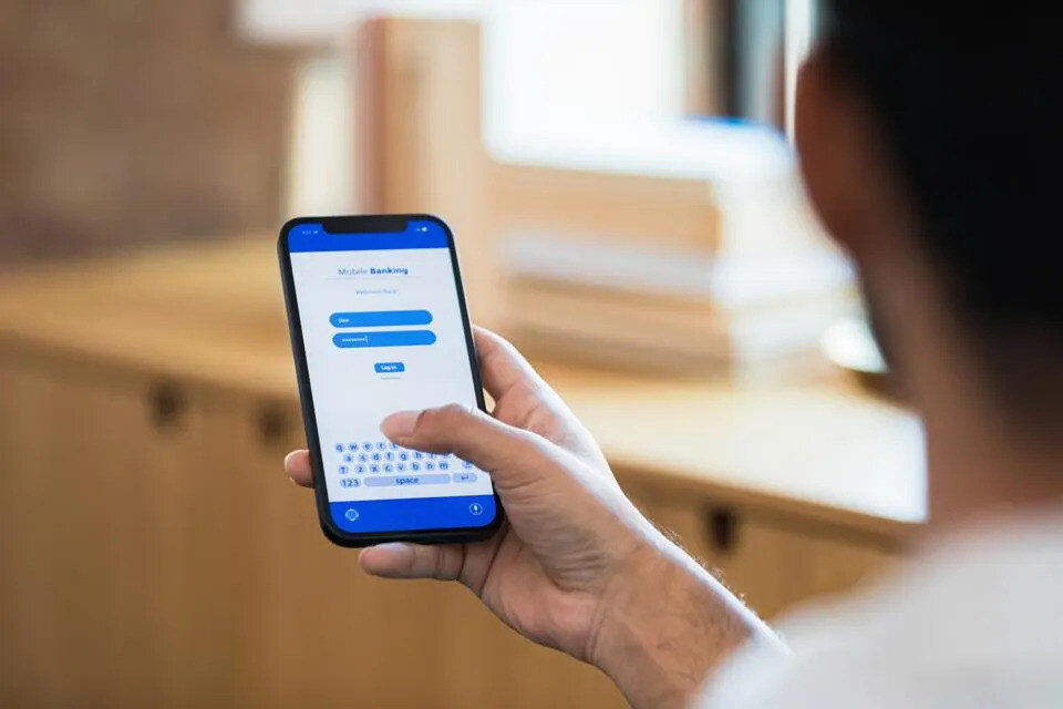 man using his mobile device to log into mobile banking for an ACH payment
