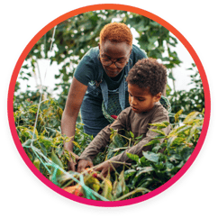 Teacher and student tending to a garden