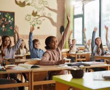 Students in a classroom raising their hands