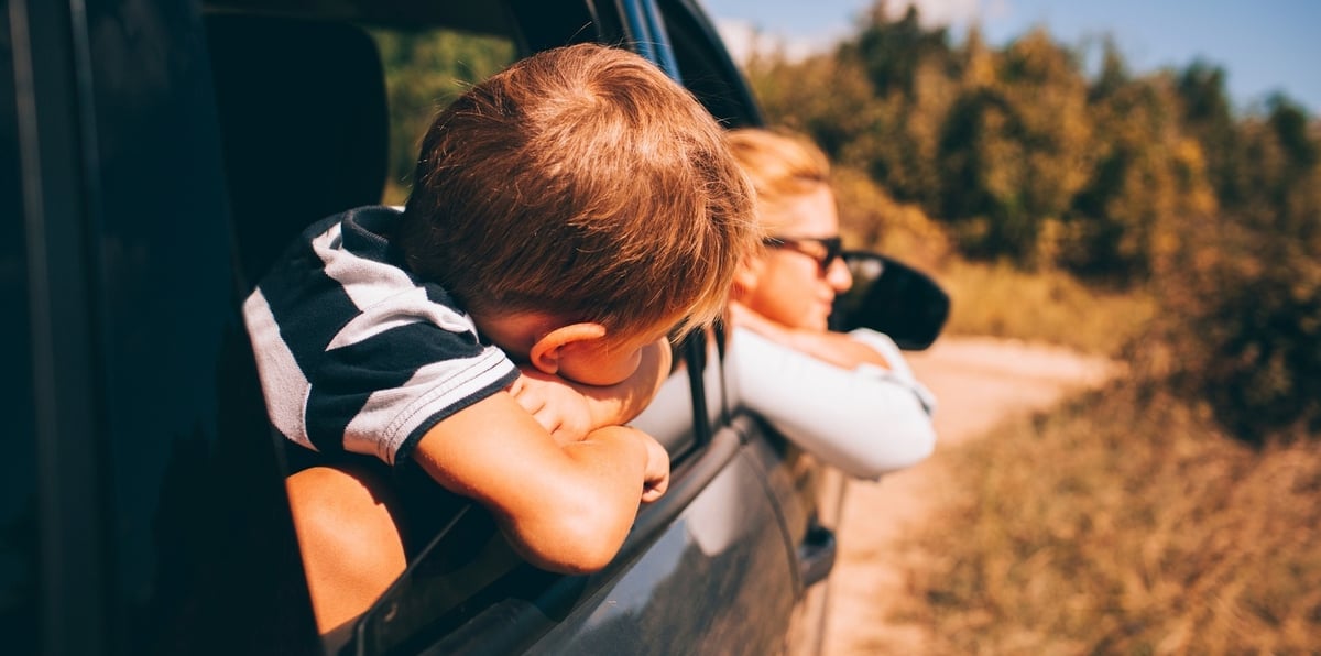 Mom and kid in car mom and kid looking out the car window on a family road trip