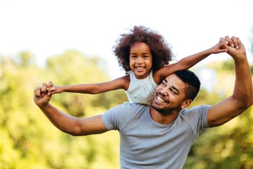 father with young daughter on his back