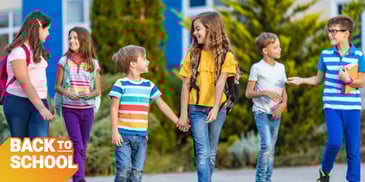 Kids with backpacks and books walking together to school