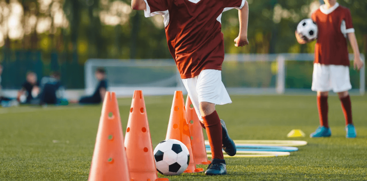 youth soccer player practicing a drill