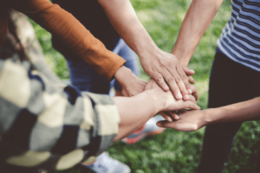 volunteer group putting their hands together