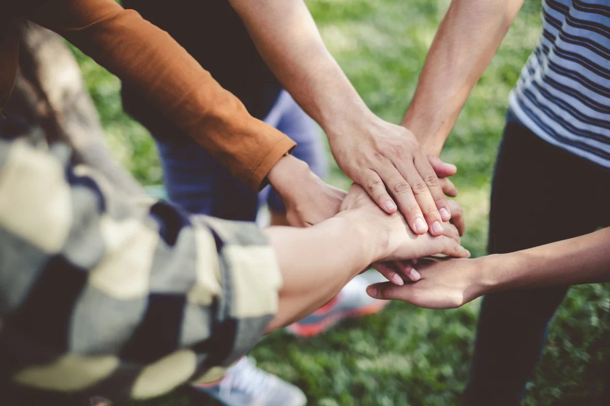 volunteer group putting their hands together
