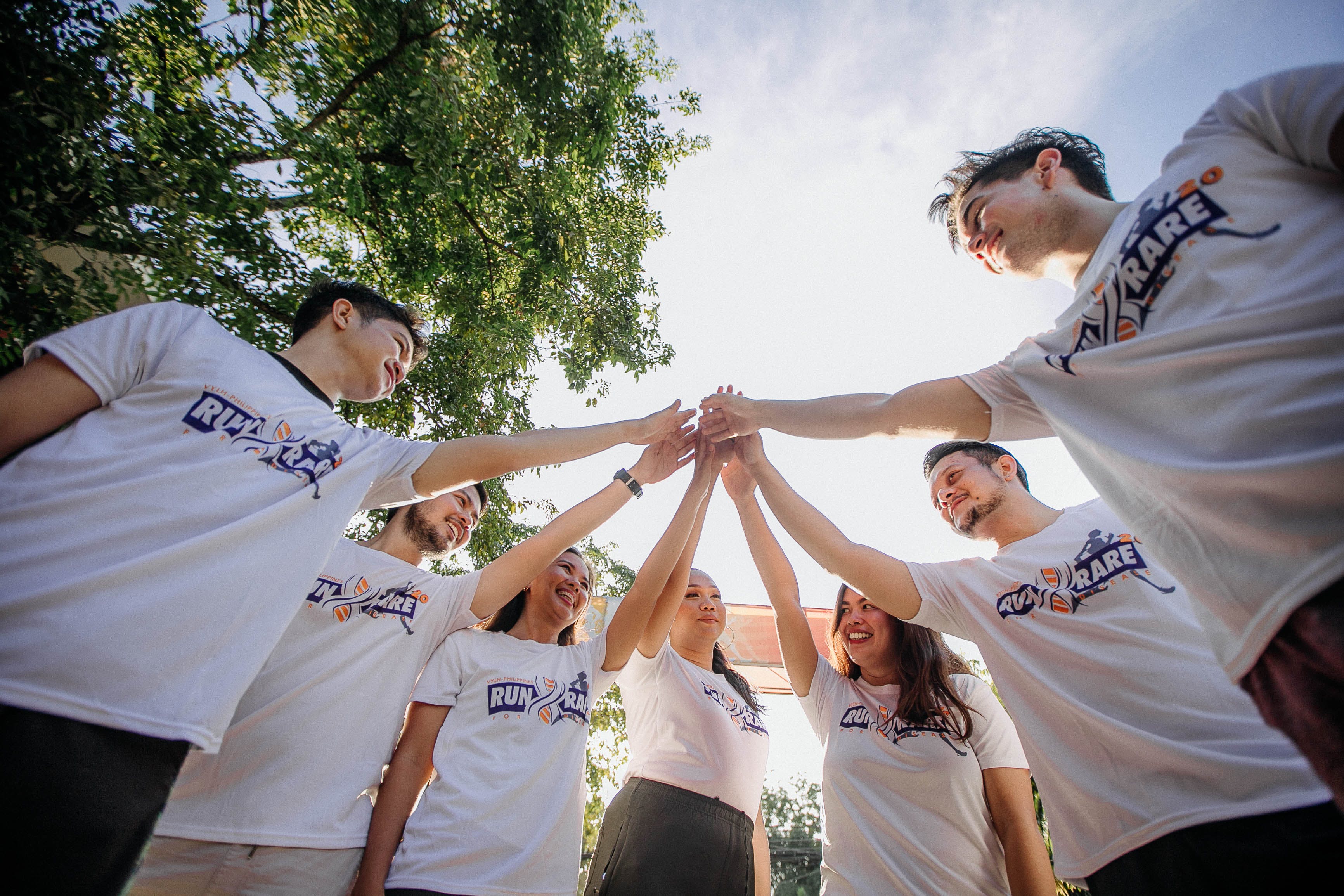group of volunteers putting their hands together in motivation